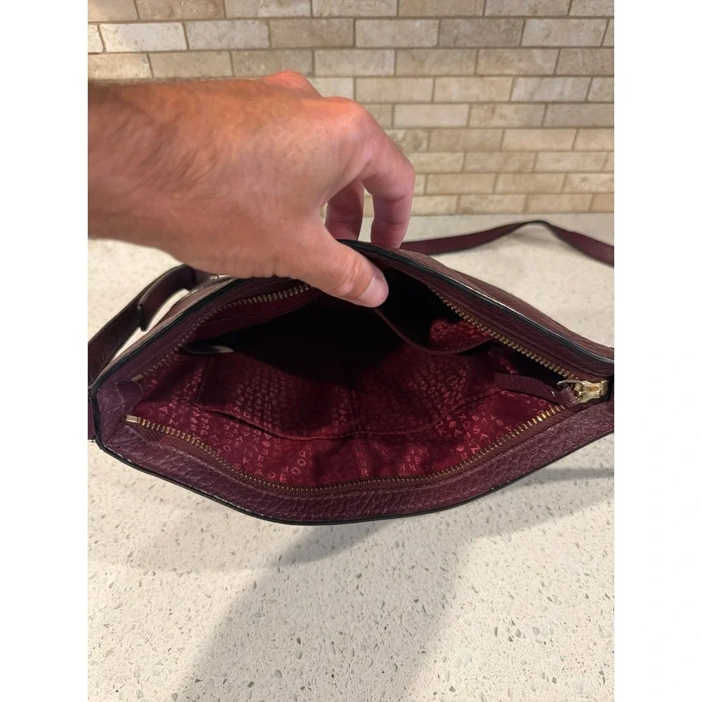 Kate Spade New York pebbled leather crossbody bag in a deep burgundy/wine color.